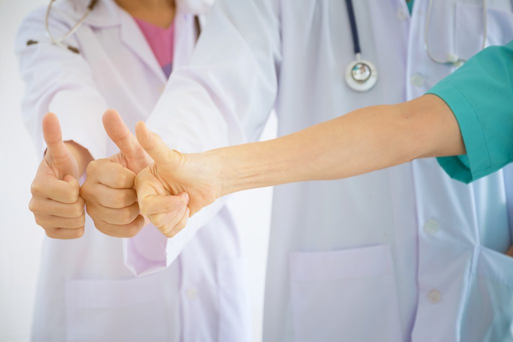 Conceito de trabalho em equipe, médicos polegares juntos no hospital. Feche as mãos da equipe médica colaborando com as mãos. Grupo de médicos bem sucedidos e enfermeiras pilha de mãos.