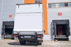 Caminhão encostado na doca de carregamento de um armazém, esperando para ser carregado